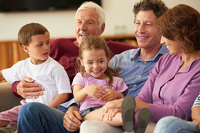 Buy stock photo Shot of a multi generational family sitting on a sofa at home
