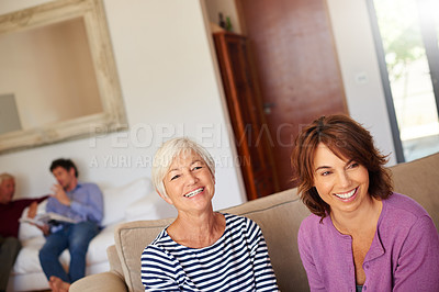 Buy stock photo Portrait of a senior woman sitting beside her daughter at home
