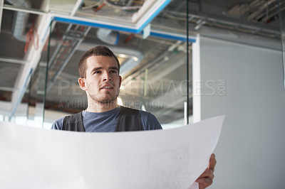 Buy stock photo One building contractor from below thinking of ideas and checking blueprint drawings while working on industrial architecture project at construction site. Engineer planning for renovation of property