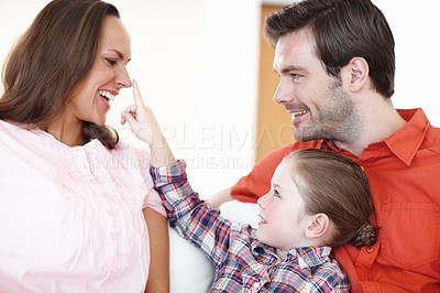 Buy stock photo Shot of a mother laughing while her daughter pokes her nose