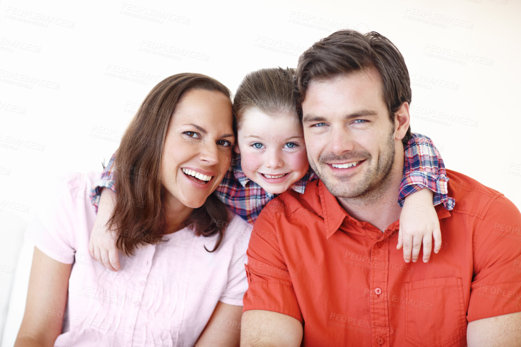 Buy stock photo Shot of a little girl posing with her arms around her mother and father