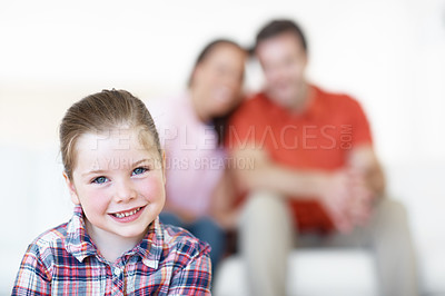 Buy stock photo A young girl smiles with her parents in the background