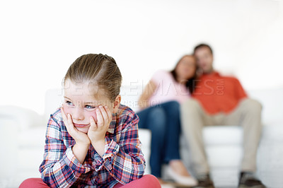Buy stock photo A  little girl sits and sulks while her parents in the background