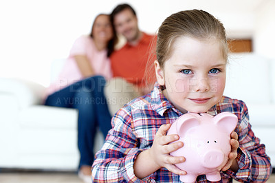 Buy stock photo A young, blonde girl clutches her piggybank