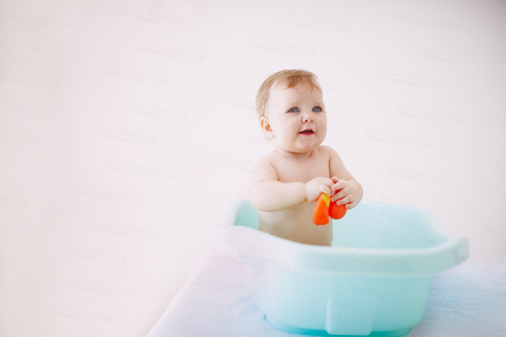 Buy stock photo Shot of a baby girl playing with a toy in the bathtub