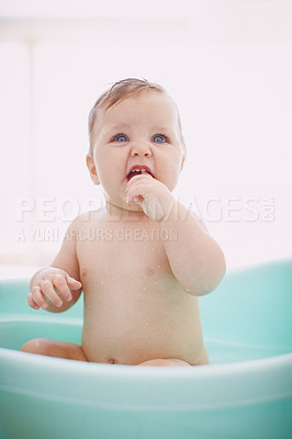 Buy stock photo Cute baby taking a bath in a tub of water at home. One playful infant kid sucking fingers while washing and bathing to stay healthy and clean with good hygiene. Little child enjoying bath time
