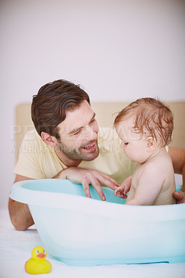Buy stock photo A young father bonding with his baby daughter at bathtime 