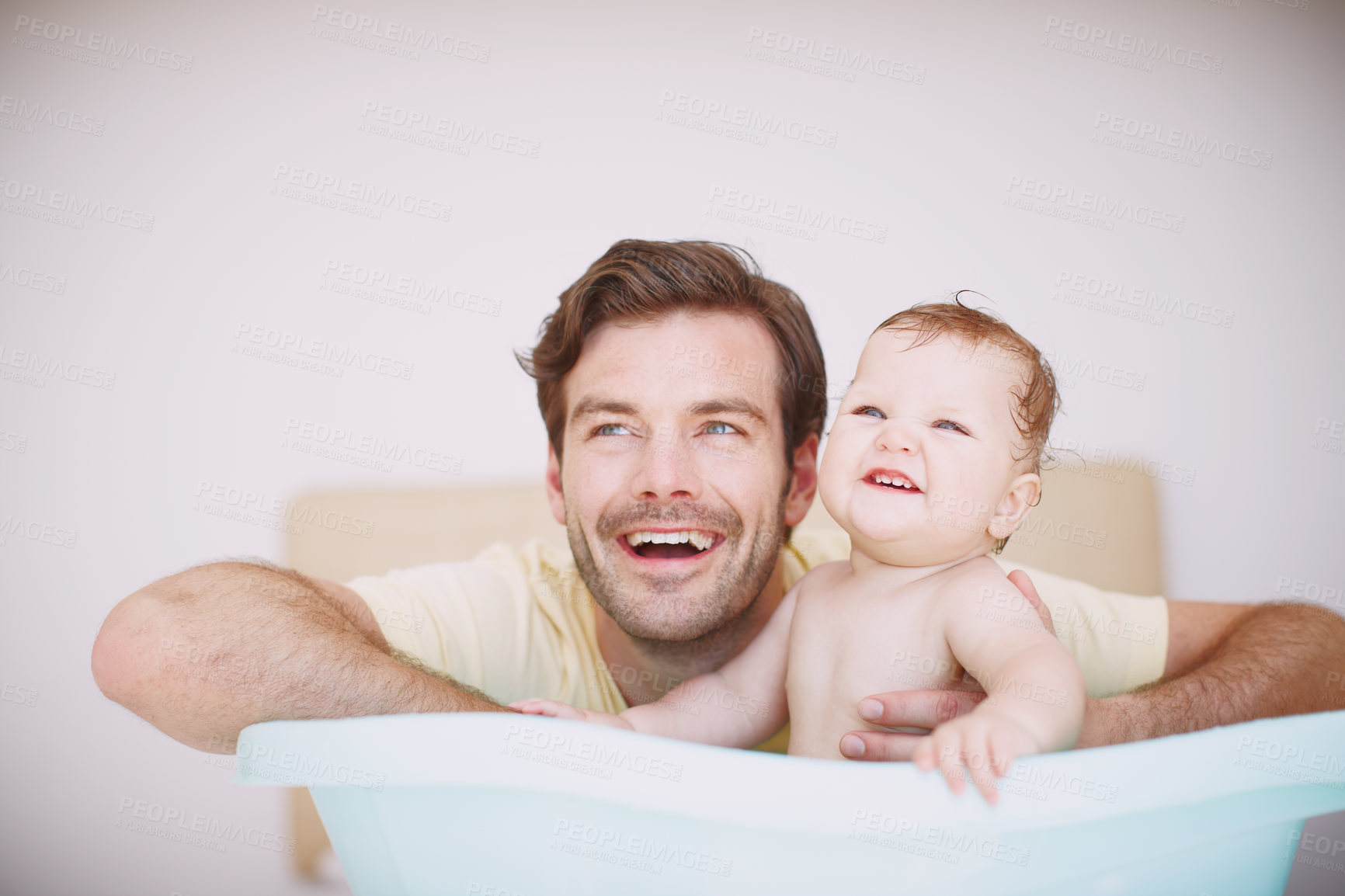 Buy stock photo A young father bonding with his baby daughter at bathtime 