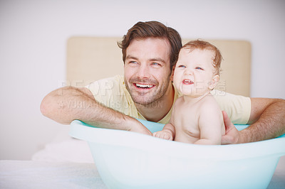 Buy stock photo A young father bonding with his baby daughter at bathtime 
