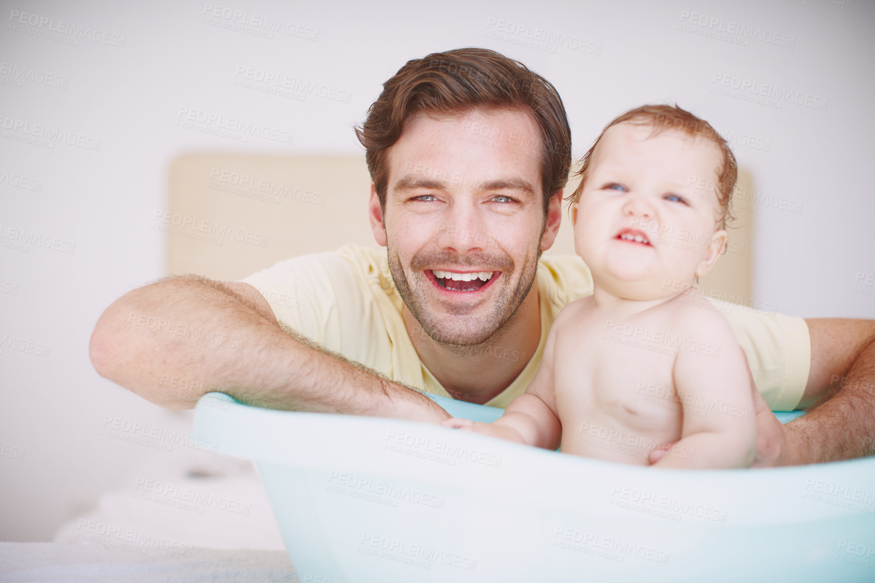 Buy stock photo A young father bonding with his baby daughter at bathtime 