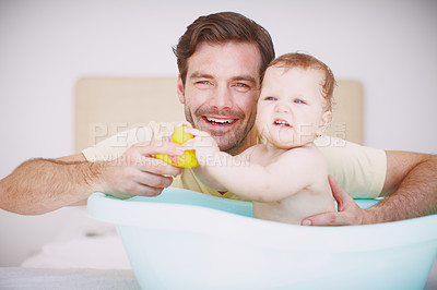 Buy stock photo Portrait of a young father bonding with his baby daughter at bathtime 