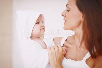 Buy stock photo A baby girl wrapped in a towel and being held by her mother