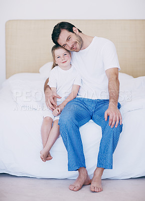 Buy stock photo Portrait of a dad and his young daughter sitting  side by side on a bed