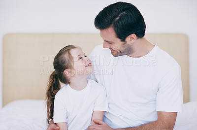 Buy stock photo Closeup shot of a father and daughter spending time together while sitting on a bed