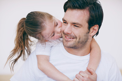 Buy stock photo A little girl giving her father a kiss on the cheek