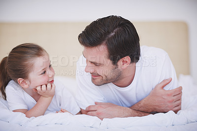 Buy stock photo A father and his little girl lying close together on a bed