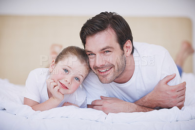 Buy stock photo A dad and his little girl lying next to each other on a bed