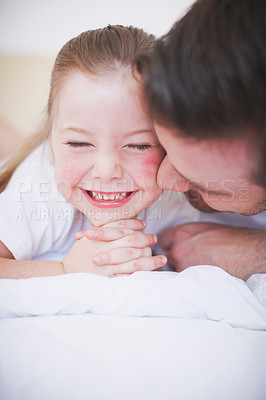 Buy stock photo A father and daughter lying side by side on the bed and being affectionate