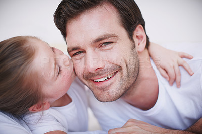 Buy stock photo A cute little girl giving her dad a kiss on the cheek