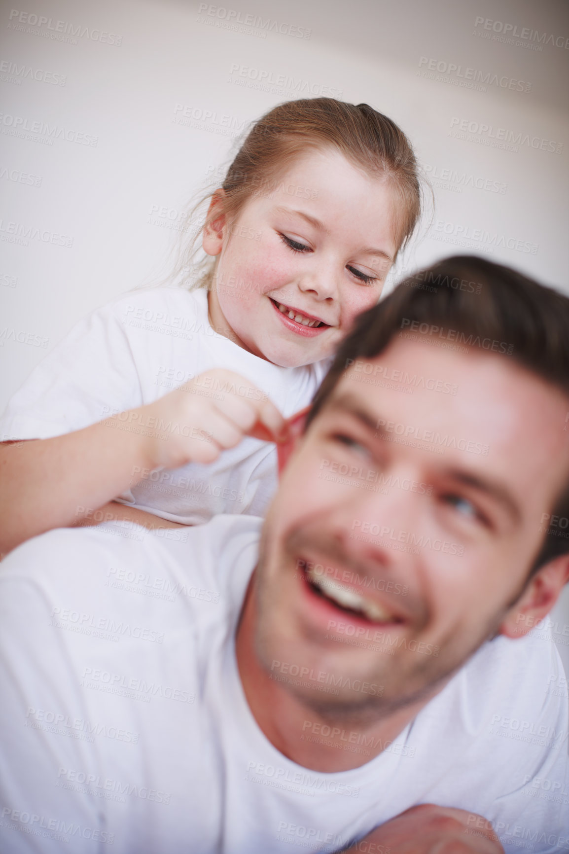 Buy stock photo Shot of a little girl sitting on her father's back and being playful