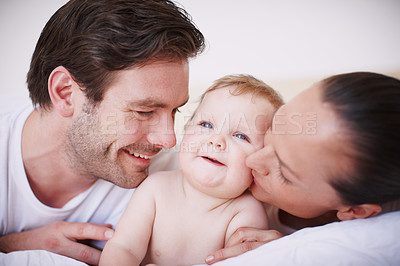 Buy stock photo Two loving young parents spending time with their adorable baby girl indoors