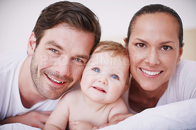 Buy stock photo Portrait of two loving young parents and their adorable baby girl