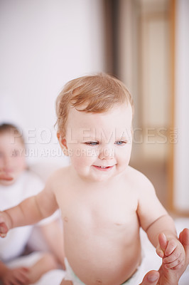 Buy stock photo Cropped shot of a baby girl standing up with the assistance of her parents 