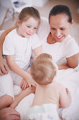 Buy stock photo High-angle view of a young mother spending time with her two daughters indoors