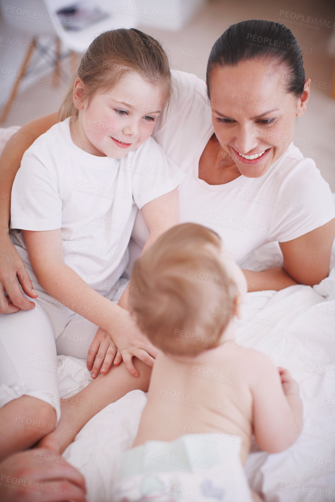 Buy stock photo High-angle view of a young mother spending time with her two daughters indoors