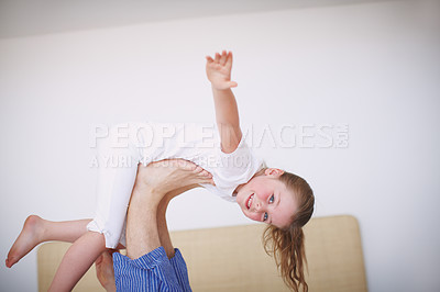 Buy stock photo Side view of a young girl propped up on her father's feet with her arms outstretched