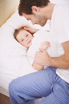 Buy stock photo A dad lovingly putting his daughter to bed