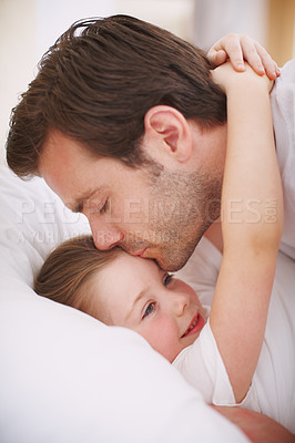 Buy stock photo A dad putting his daughter to bed and giving her a goodnight kiss