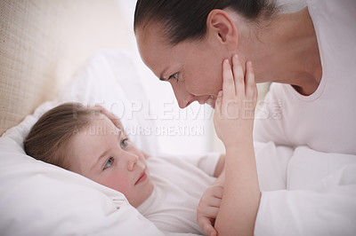 Buy stock photo Closeup shot of a mother lovingly putting her young daughter to bed