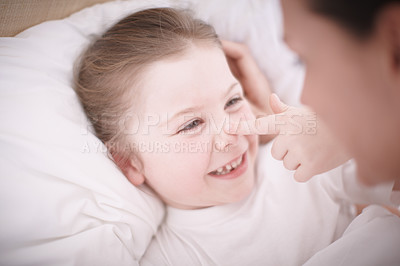 Buy stock photo Closeup of a mother putting her smiling young daughter to bed