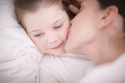 Buy stock photo A mom giving her young daughter a goodnight kiss
