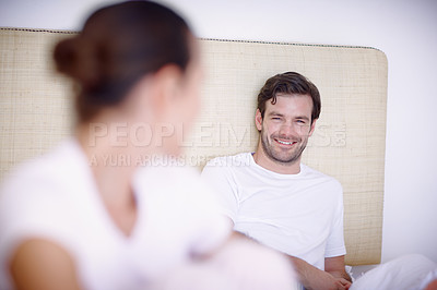 Buy stock photo Closeup shot of a young couple sitting together on a bed