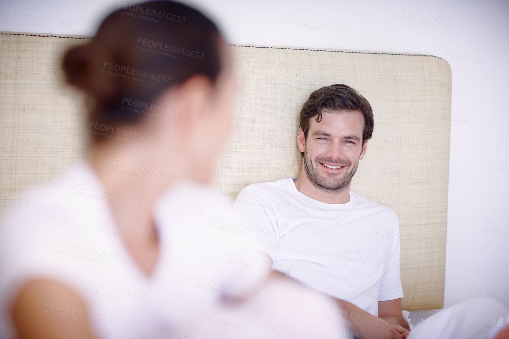 Buy stock photo Closeup shot of a young couple sitting together on a bed