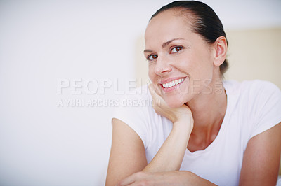 Buy stock photo A beautiful young woman relaxing on her bed with her head resting on her hand