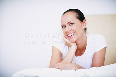 Buy stock photo Shot of a beautiful young woman relaxing on her bed with her head resting on her hand