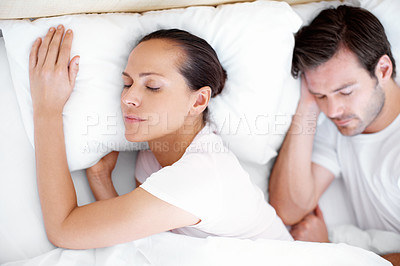 Buy stock photo Shot of a young couple sleeping peacefully in bed
