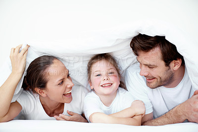 Buy stock photo A young family plying under neath the bedsheets 