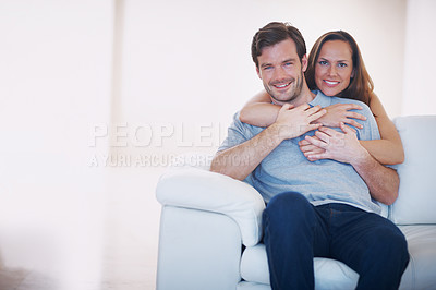 Buy stock photo Portrait of a happy young couple being affectionate in their living room