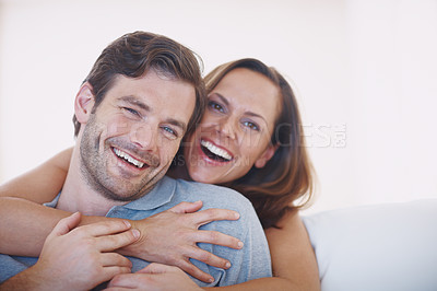 Buy stock photo An affectionate and happy young couple spending time together indoors
