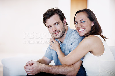 Buy stock photo Portrait of a young married couple sitting together in their living room