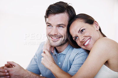 Buy stock photo An affectionate young couple sitting together indoors