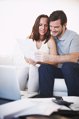 Buy stock photo A young married couple discussing their home finances together