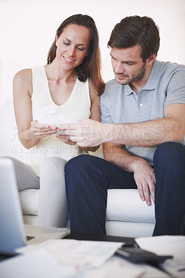 Buy stock photo A married couple inspecting bills as they do their home finances
