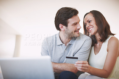 Buy stock photo A married couple being affectionate while doing their online banking together