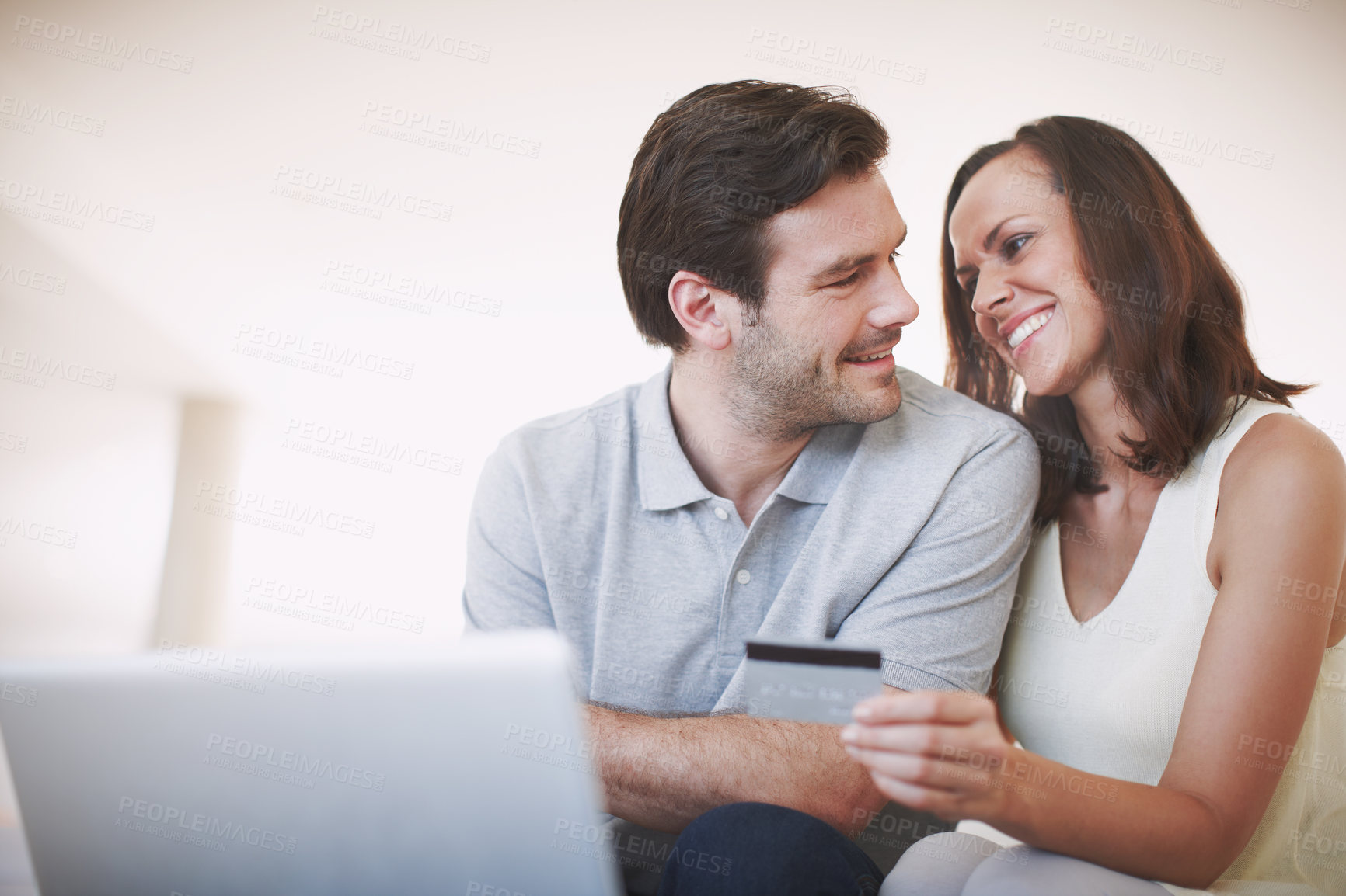 Buy stock photo A married couple being affectionate while doing their online banking together