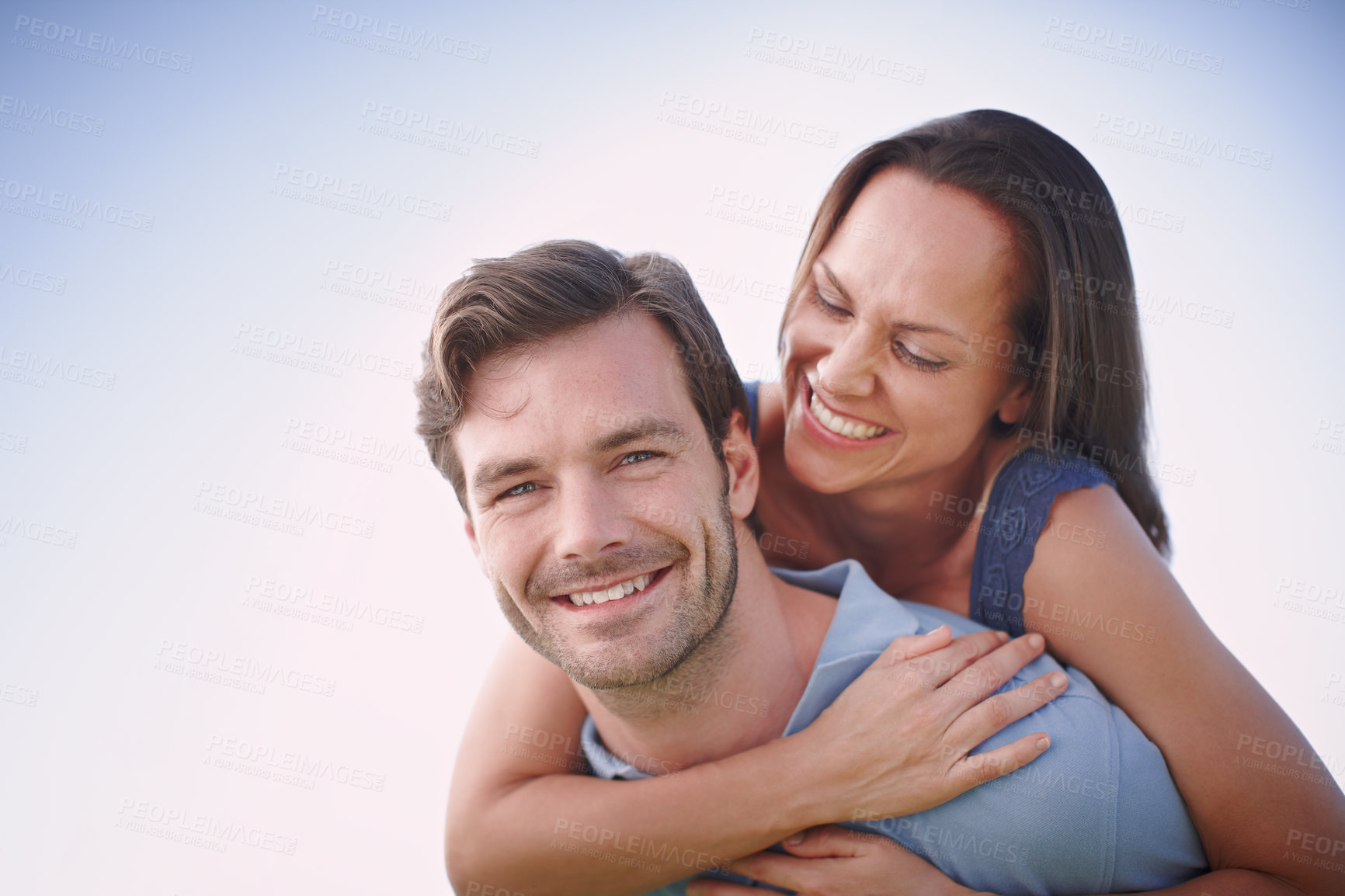 Buy stock photo A handsome man piggybacking his loving wife outdoors